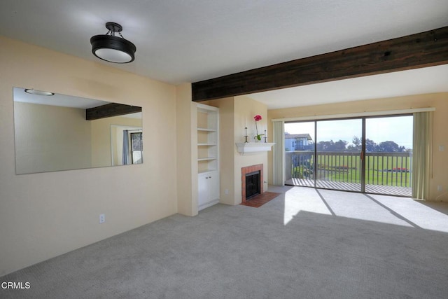 unfurnished living room featuring a brick fireplace, built in shelves, light colored carpet, and beamed ceiling