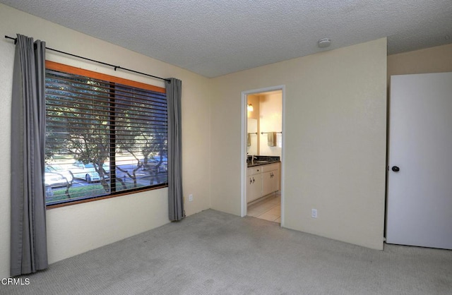 carpeted spare room featuring a textured ceiling