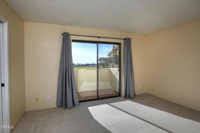 carpeted empty room with a textured ceiling