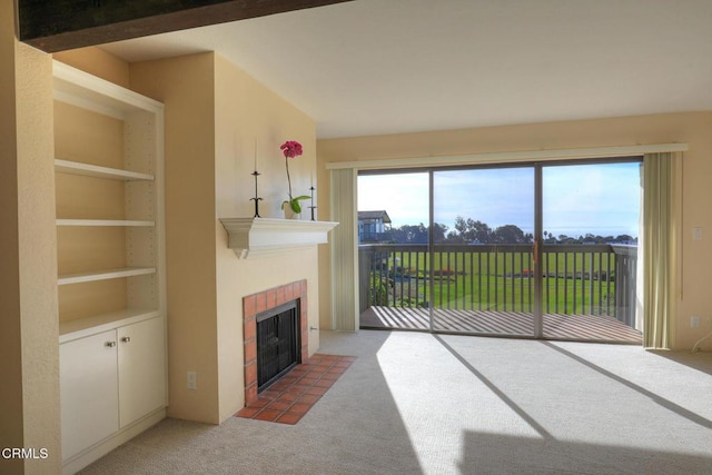 carpeted living room featuring built in shelves and a tiled fireplace