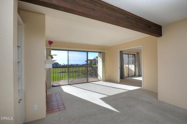 carpeted empty room with beam ceiling