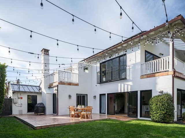 back of house with a patio area, a yard, and a balcony