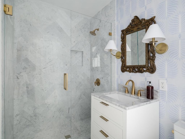 bathroom featuring a shower with door and vanity