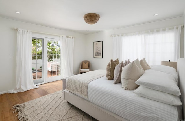 bedroom with hardwood / wood-style floors and access to outside