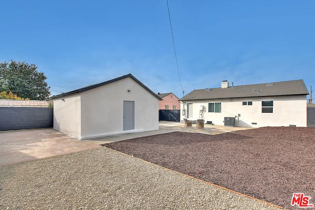 back of property with central AC unit and a patio area