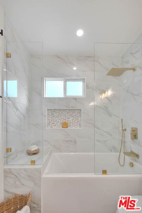 bathroom with bath / shower combo with glass door