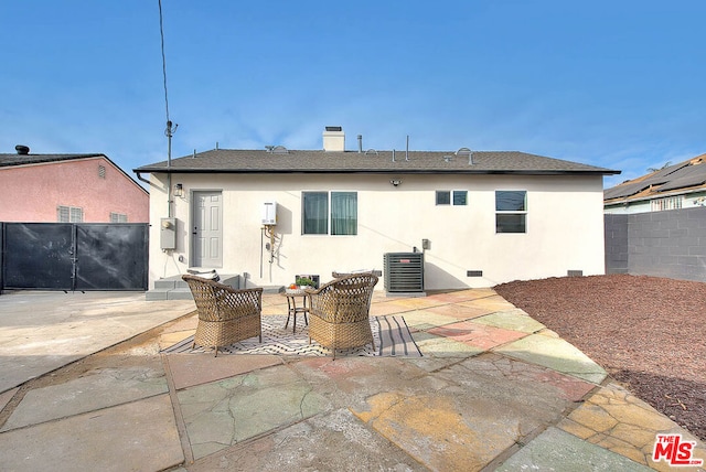 rear view of property with central AC unit and a patio