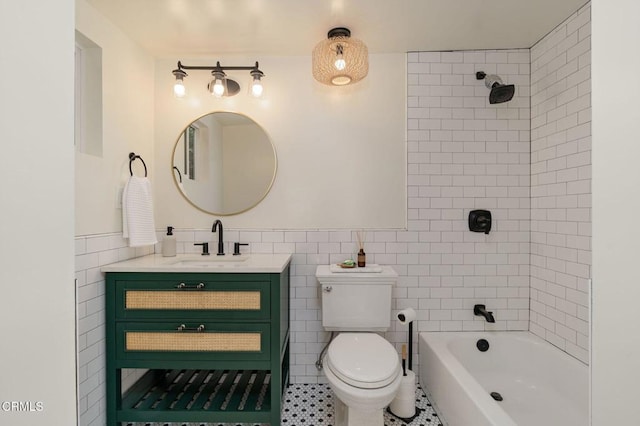 full bathroom featuring tile walls, tile patterned flooring, tiled shower / bath combo, vanity, and toilet