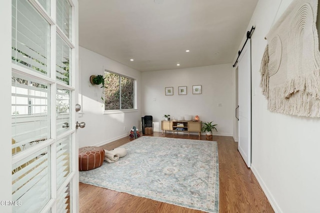 sitting room featuring wood-type flooring and a barn door