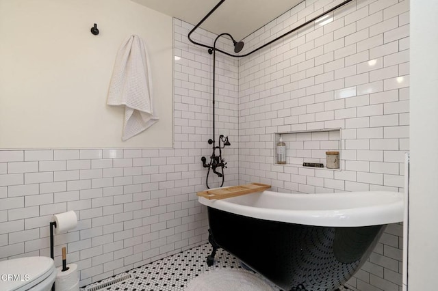 bathroom with tile patterned flooring, separate shower and tub, tile walls, and toilet