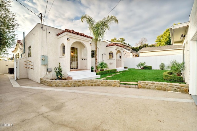 mediterranean / spanish home featuring a front lawn