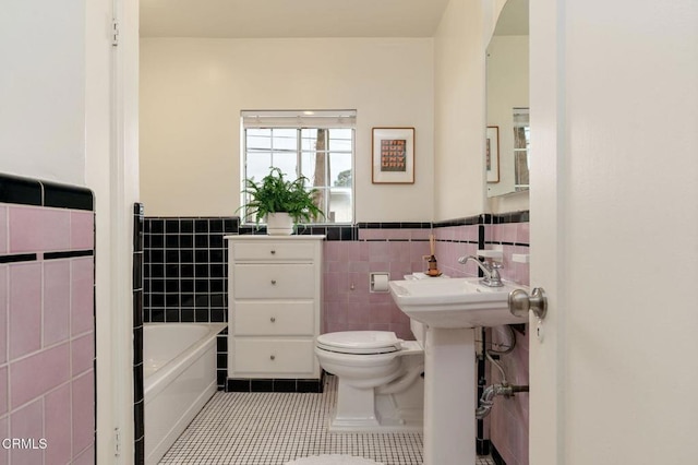 bathroom with sink, tile walls, a bath, tile patterned floors, and toilet