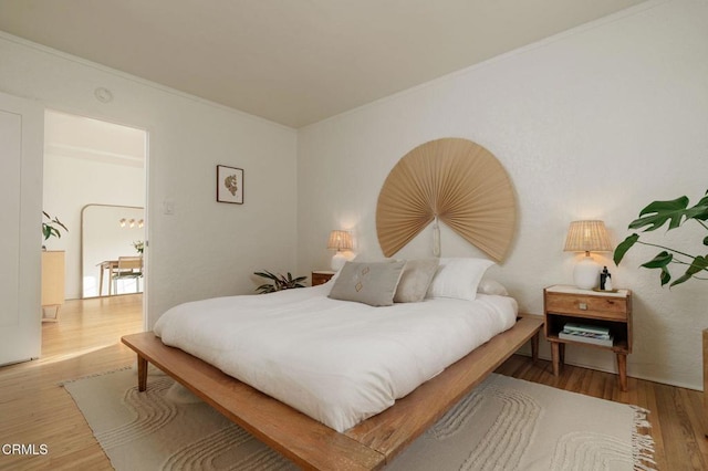 bedroom featuring hardwood / wood-style floors and crown molding