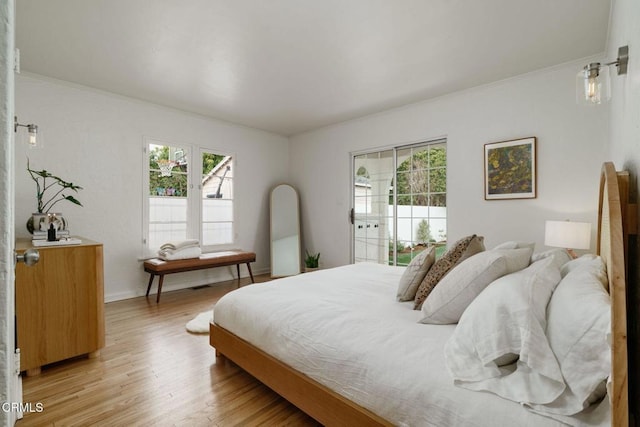 bedroom featuring ornamental molding and light hardwood / wood-style flooring