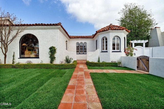 mediterranean / spanish house with a pergola and a front lawn