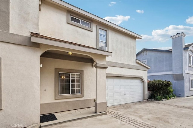 view of front of property with a garage, driveway, and stucco siding