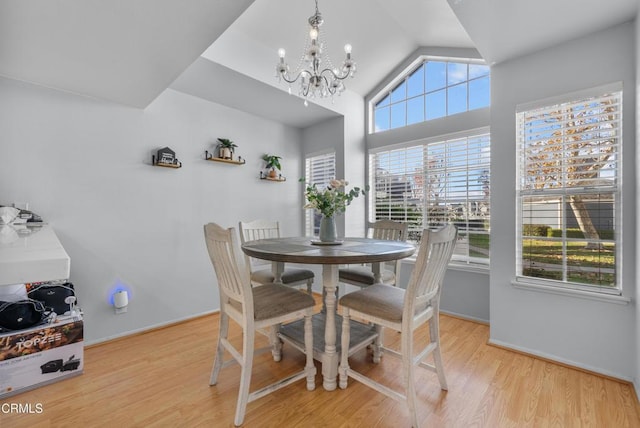 dining space featuring light wood-type flooring, a wealth of natural light, and a notable chandelier