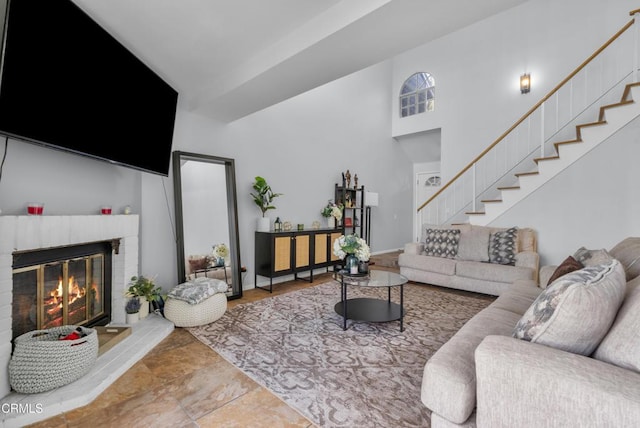 living room with a brick fireplace and a high ceiling