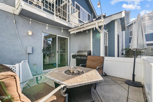 view of patio / terrace with a balcony, area for grilling, and a fire pit