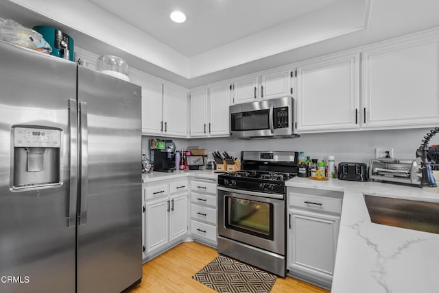 kitchen featuring white cabinetry, appliances with stainless steel finishes, and light wood-type flooring