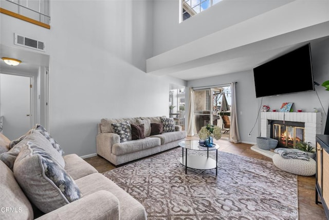 living room featuring a fireplace and a towering ceiling