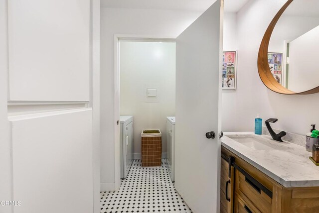 bathroom featuring washing machine and clothes dryer and vanity