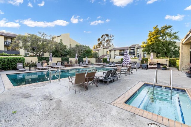 view of swimming pool with a community hot tub and a patio area