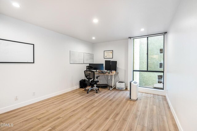 home office with light hardwood / wood-style flooring