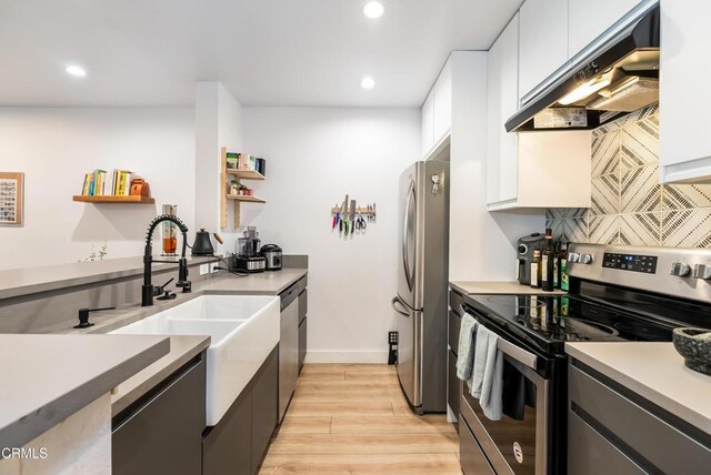 kitchen featuring sink, stainless steel appliances, ventilation hood, white cabinets, and light wood-type flooring