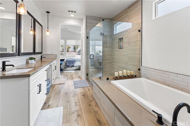 bathroom featuring vanity, wood-type flooring, and plus walk in shower