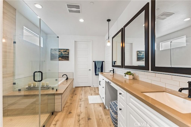 bathroom featuring tasteful backsplash, vanity, shower with separate bathtub, and hardwood / wood-style flooring