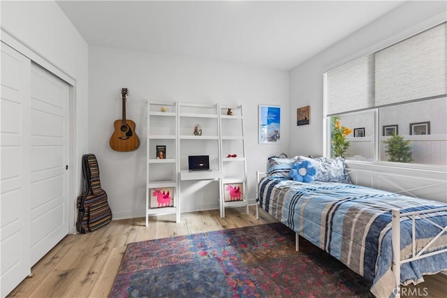 bedroom with light hardwood / wood-style floors and a closet