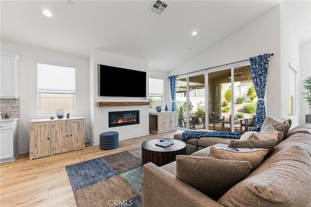 living room with vaulted ceiling and light hardwood / wood-style floors