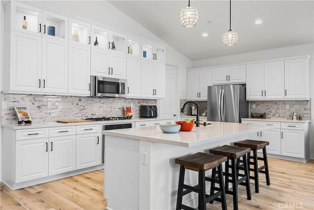 kitchen featuring a kitchen island with sink, white cabinetry, and stainless steel appliances