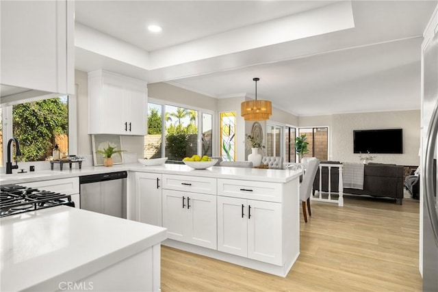 kitchen with white cabinets, kitchen peninsula, dishwasher, and pendant lighting