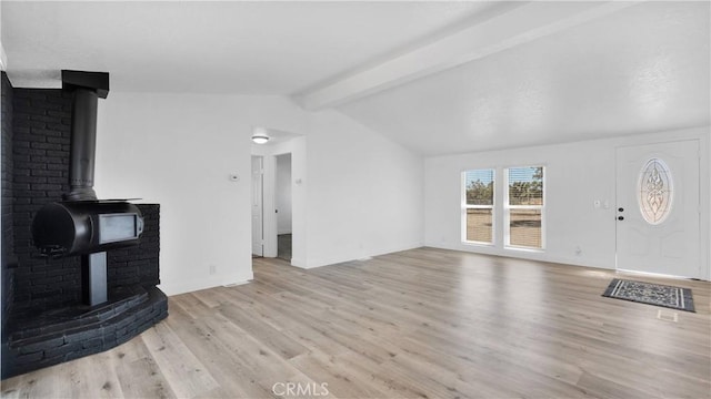 living room with lofted ceiling with beams, a wood stove, and light hardwood / wood-style floors