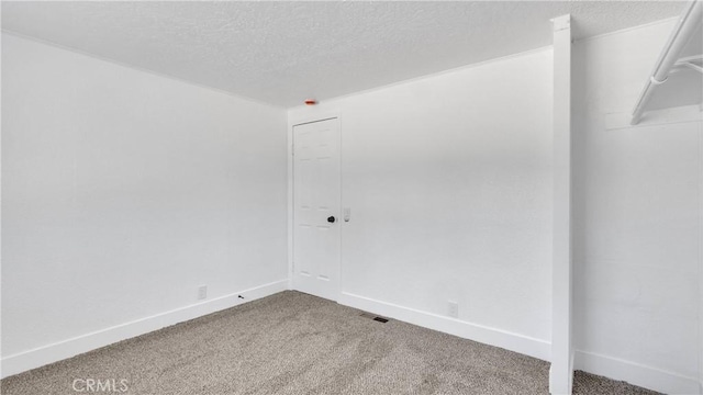 carpeted spare room with a textured ceiling