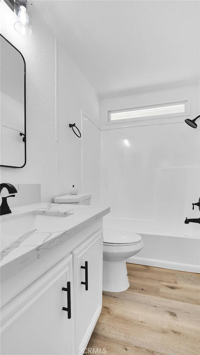 full bathroom featuring toilet, vanity, shower / bathtub combination, and hardwood / wood-style flooring