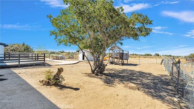 view of yard with a playground and a storage unit