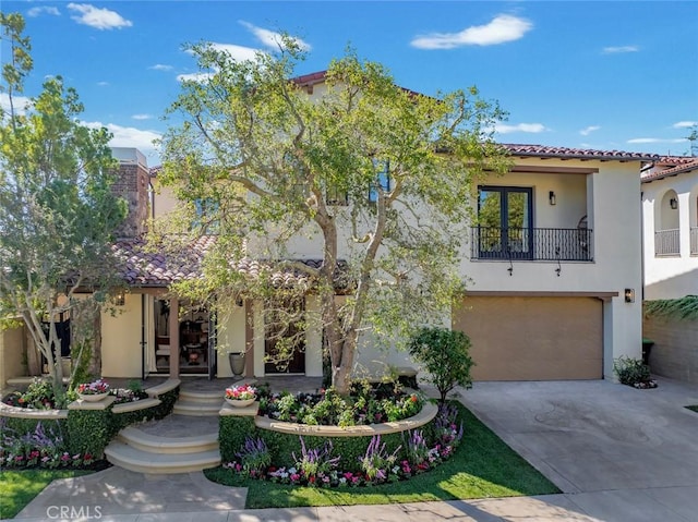 mediterranean / spanish-style house featuring a balcony, a garage, and french doors