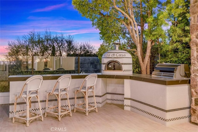 patio terrace at dusk with exterior kitchen