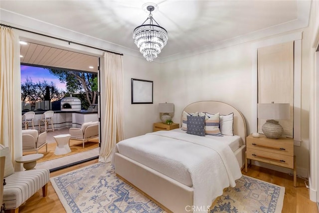 bedroom with light wood-type flooring and a notable chandelier