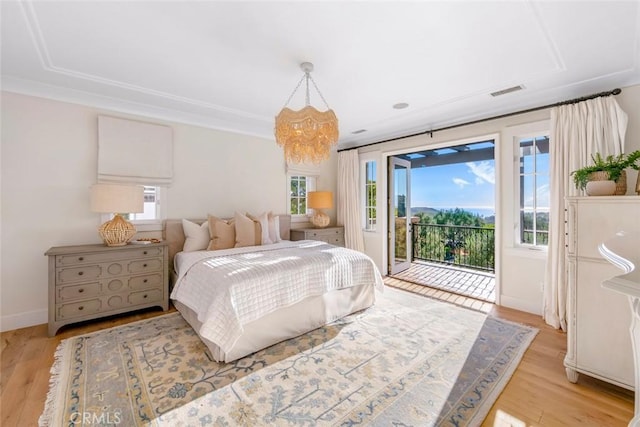 bedroom with light wood-type flooring, access to exterior, and multiple windows