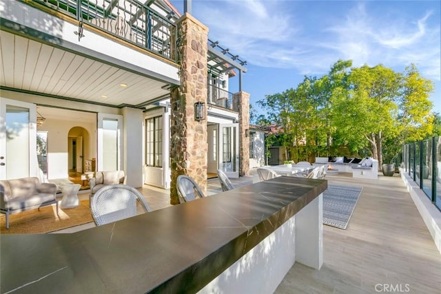 view of patio featuring a balcony and a bar