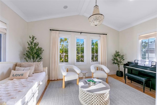 sitting room featuring hardwood / wood-style floors, ornamental molding, lofted ceiling, and a notable chandelier