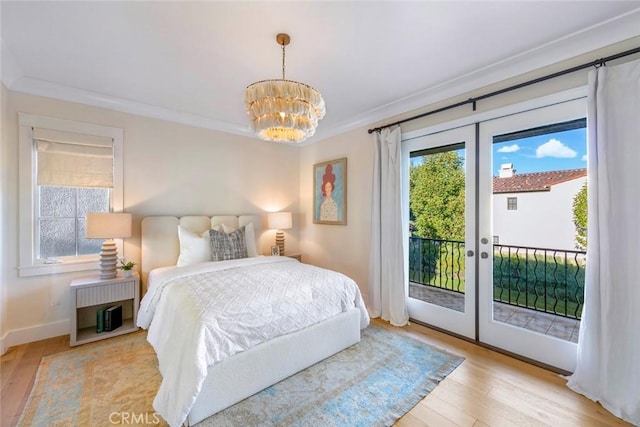 bedroom with french doors, an inviting chandelier, access to exterior, ornamental molding, and light hardwood / wood-style flooring