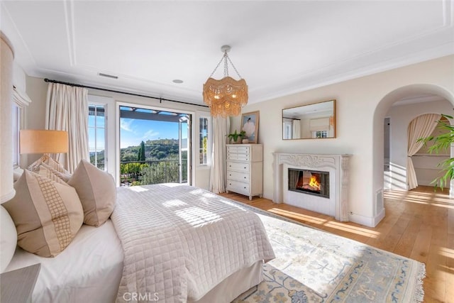 bedroom featuring access to outside, light wood-type flooring, and crown molding