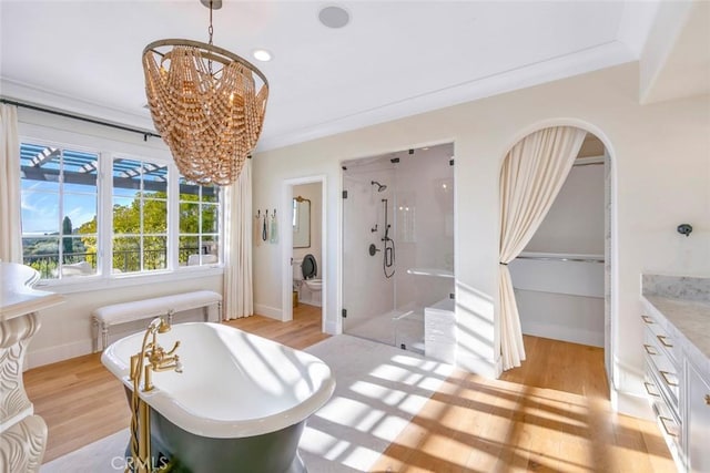 bathroom featuring separate shower and tub, vanity, wood-type flooring, ornamental molding, and a chandelier