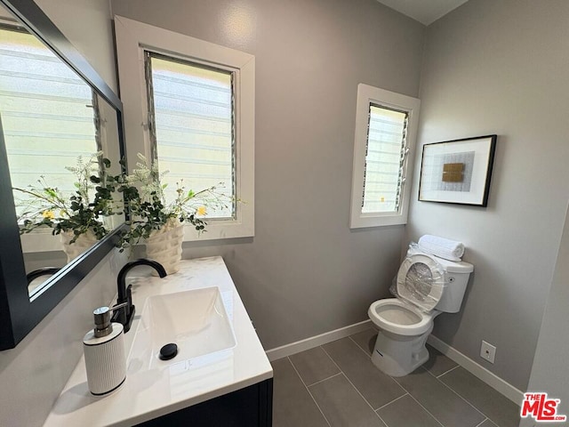 bathroom featuring vanity, tile patterned floors, and toilet