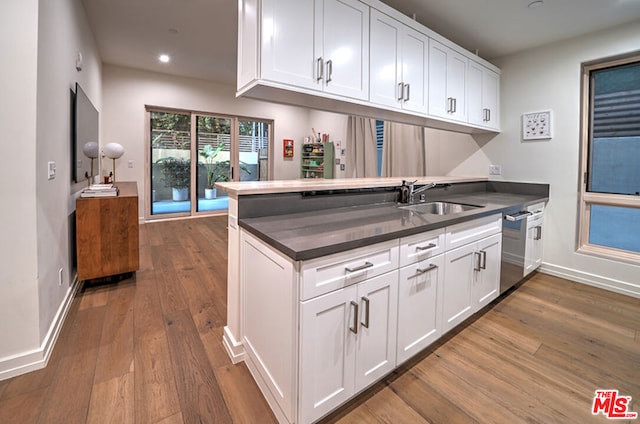 kitchen featuring kitchen peninsula, dishwasher, white cabinets, and sink